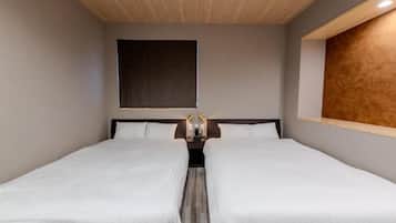 A hotel room with two single beds, a large window, and a wooden ceiling.