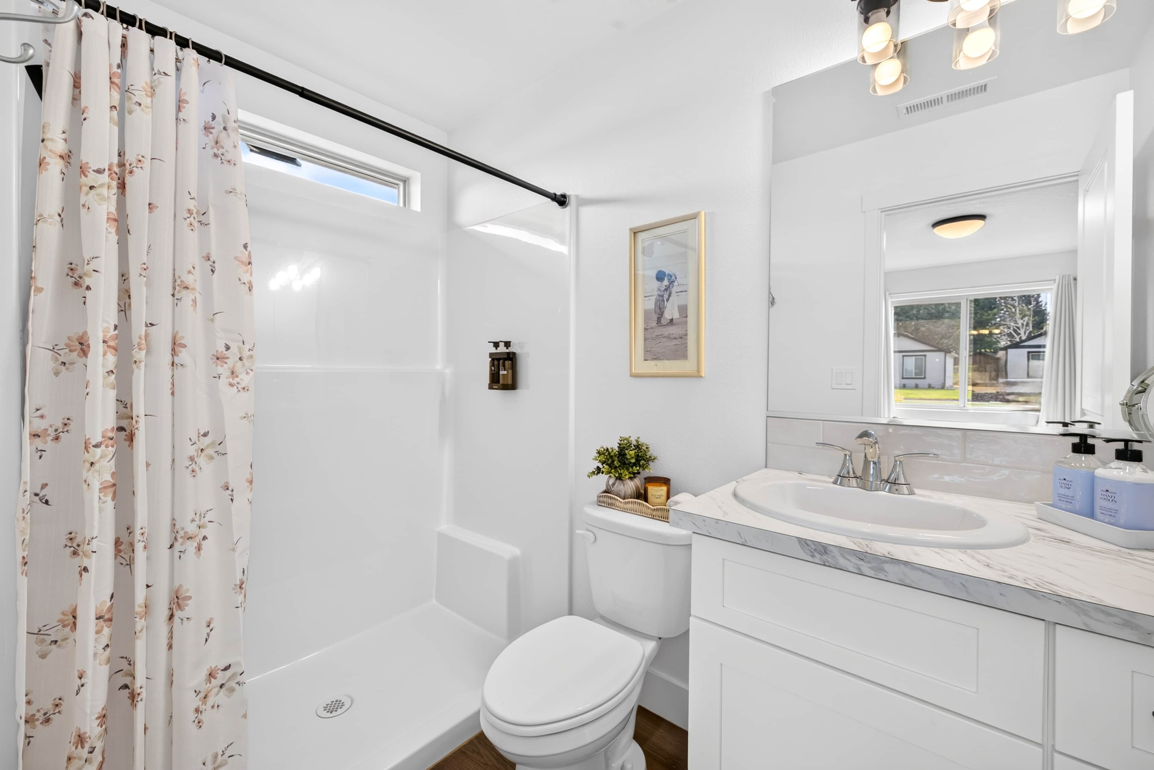 A modern bathroom with a shower, toilet, and sink.