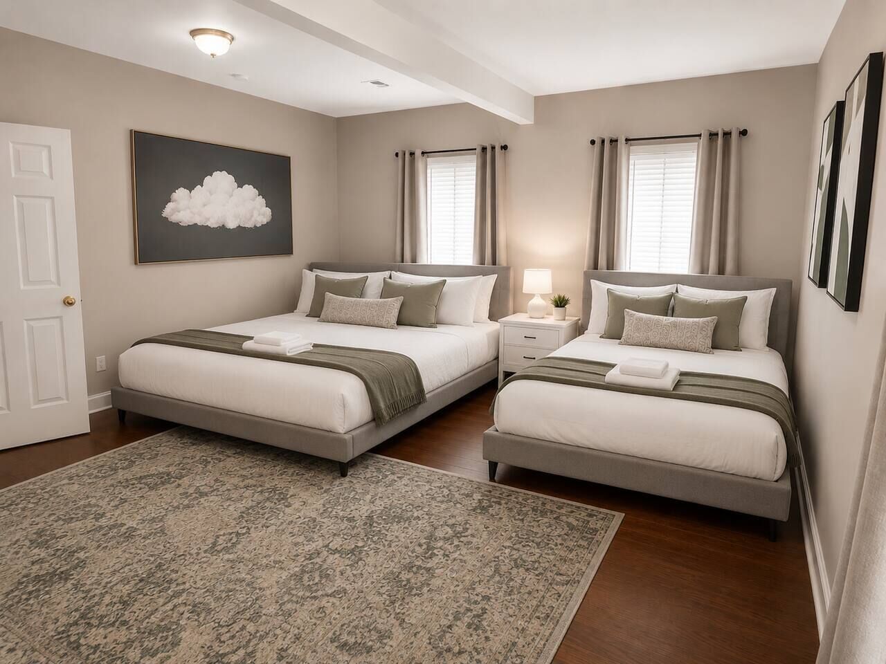 Une chambre avec deux lits, une grande moquette, un luminaire fixé au mur et un tableau sur le thème des nuages.
