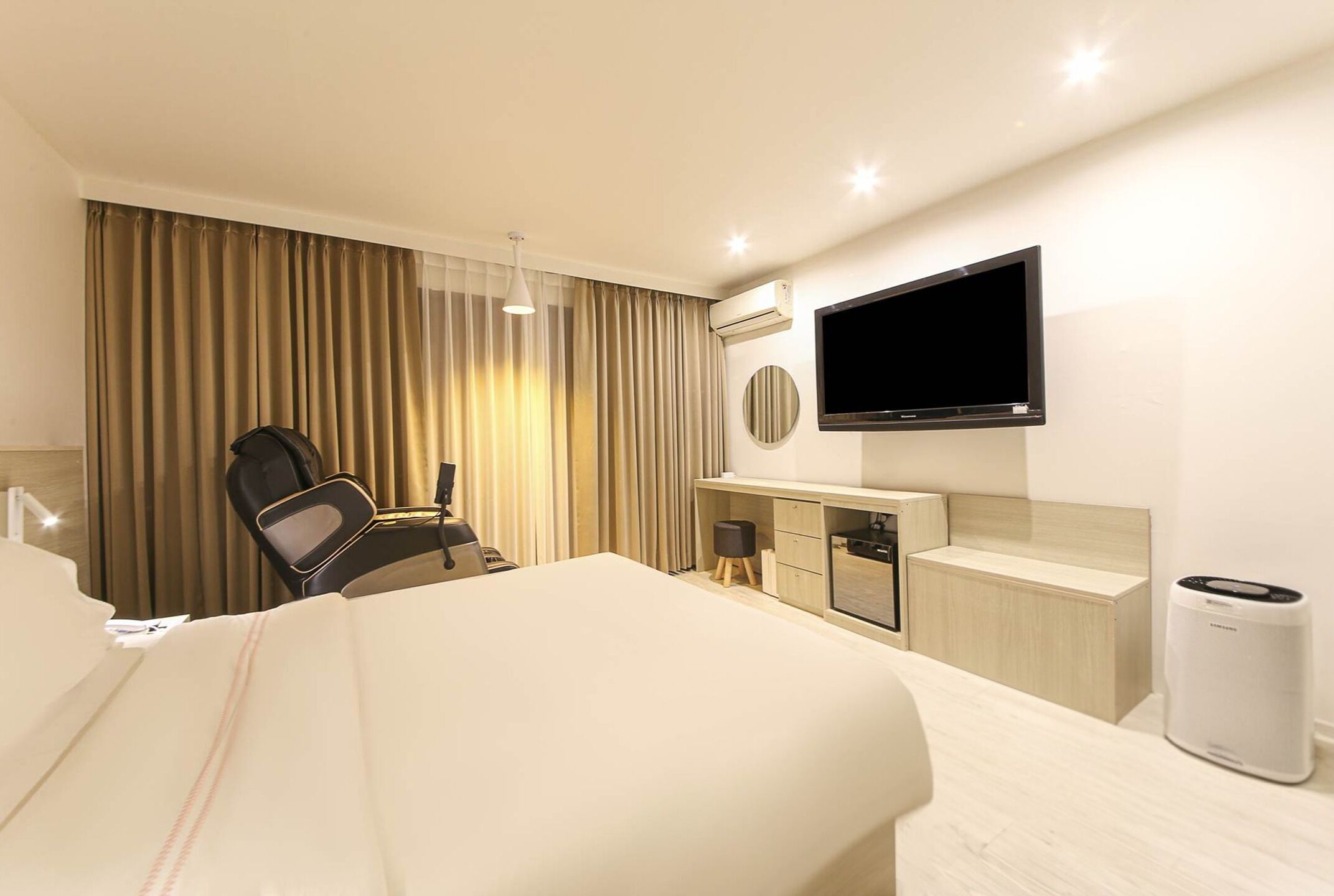 Hotelkamer met een bed, een bureau, een stoel, een televisie en een airconditioning.