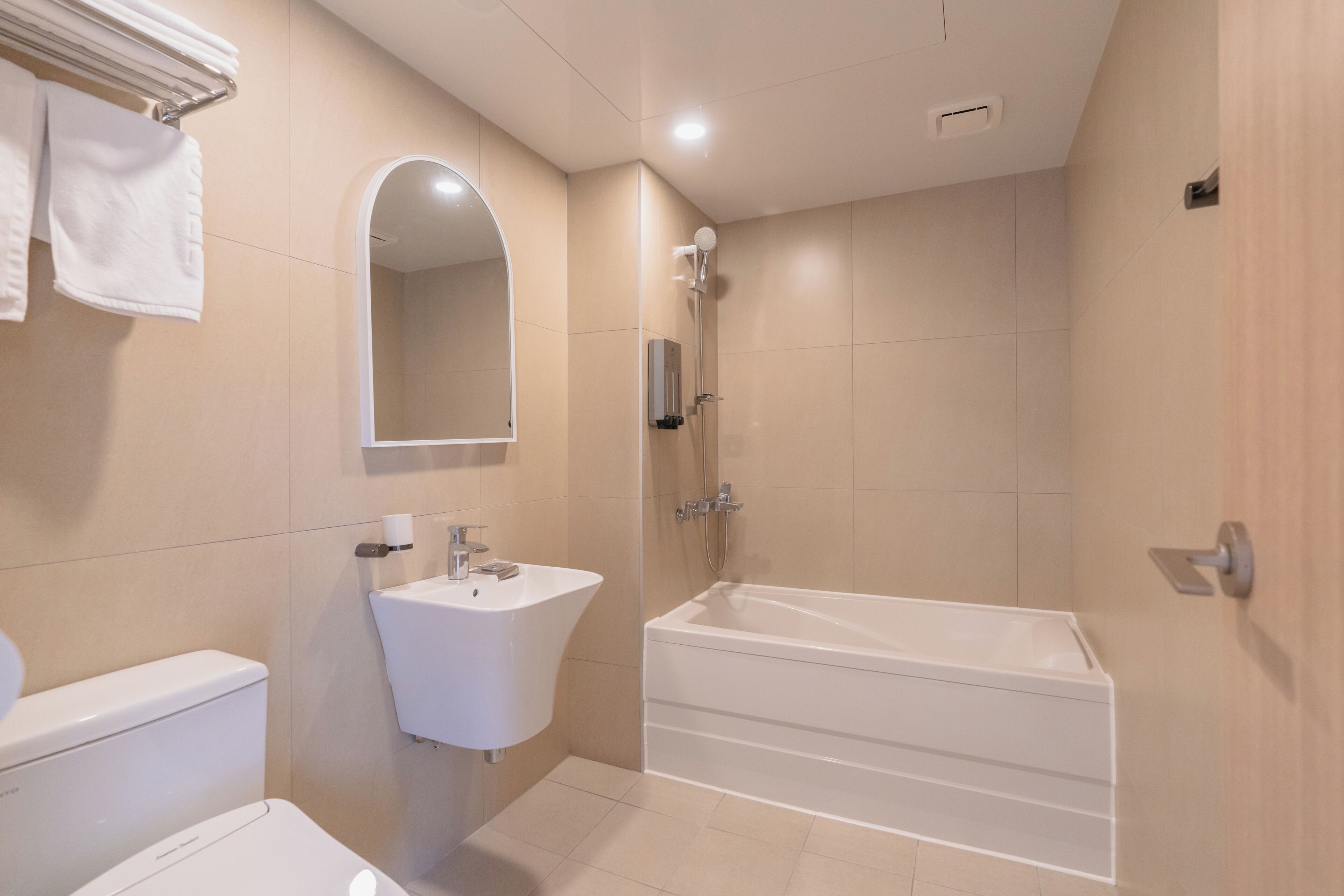 Un baño moderno con inodoro, lavamanos y bañera.