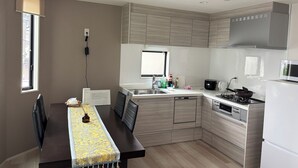 A modern kitchen with a dining table, built-in appliances, and a window. - Modern Newly Build 3BR Villa Near Asakusa & Skytree 3minutes to Station (Sumida Ward)