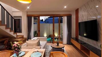 A modern living room with a dining area, a staircase, and a TV mounted on the wall.