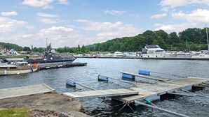 A marina with boats docked, wooden piers, and a backdrop of trees and houses. - 4 bedroom gorgeous home in Melsomvik (Sandefjord) (Melsomvik (Sandefjord))