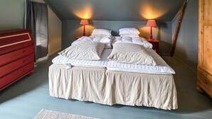 A bedroom with a large bed, two bedside tables, a red dresser, and a sloped ceiling. - 4 bedroom gorgeous home in Melsomvik (Sandefjord) (Melsomvik (Sandefjord))