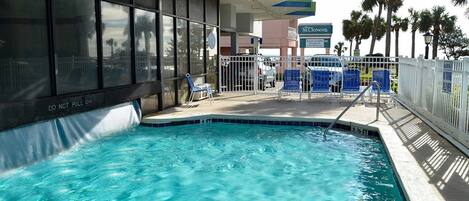 A swimming pool with a 'DO NOT PULL ON' sign, a fenced area with lounge chairs, and a sign for 'St. Clement's'.