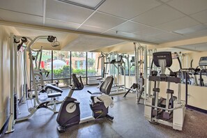 Un gimnasio con máquinas de cardio, máquinas de pesas y un espejo grande.