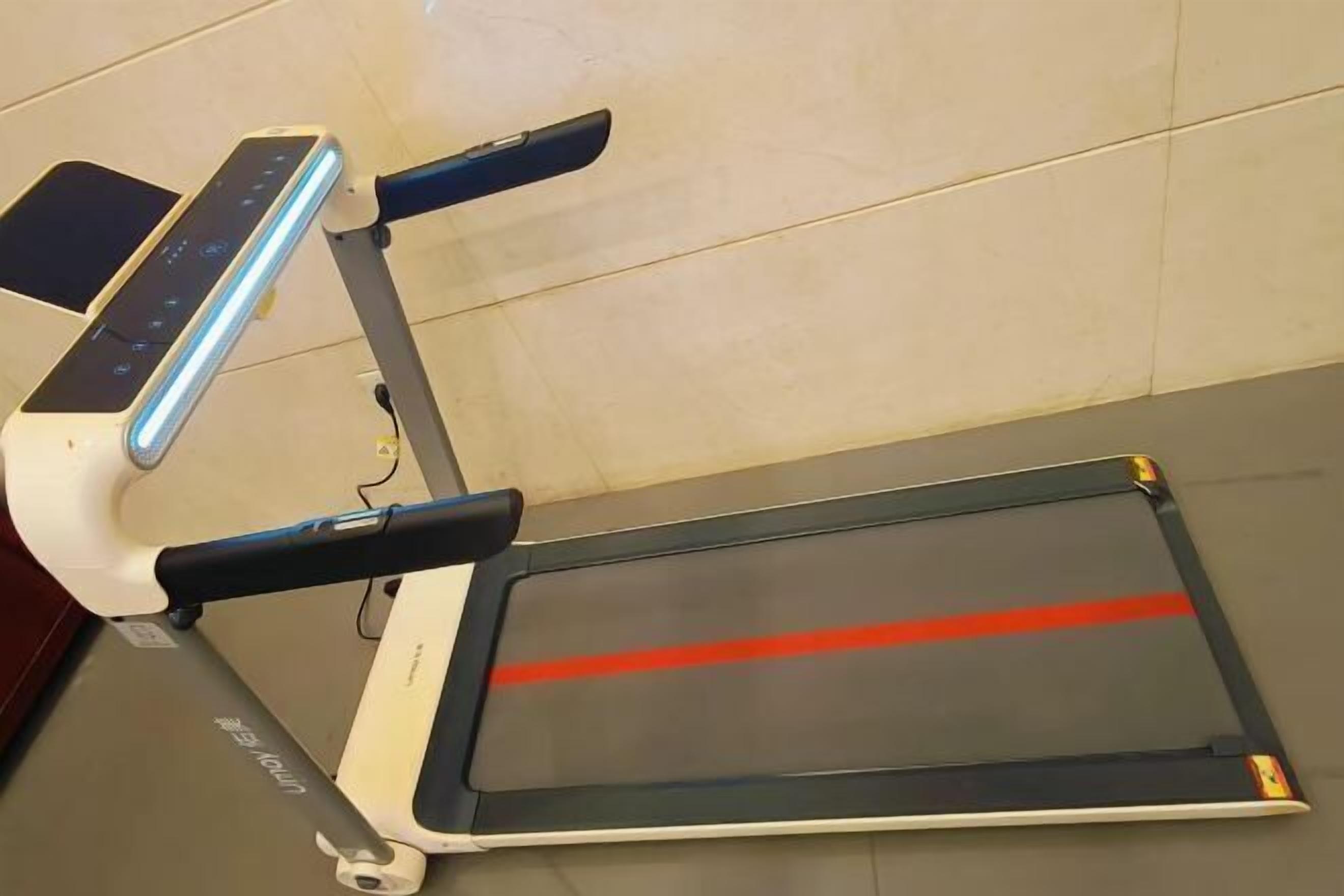 Un tapis de course doté d’un écran numérique et d’une piste rouge.