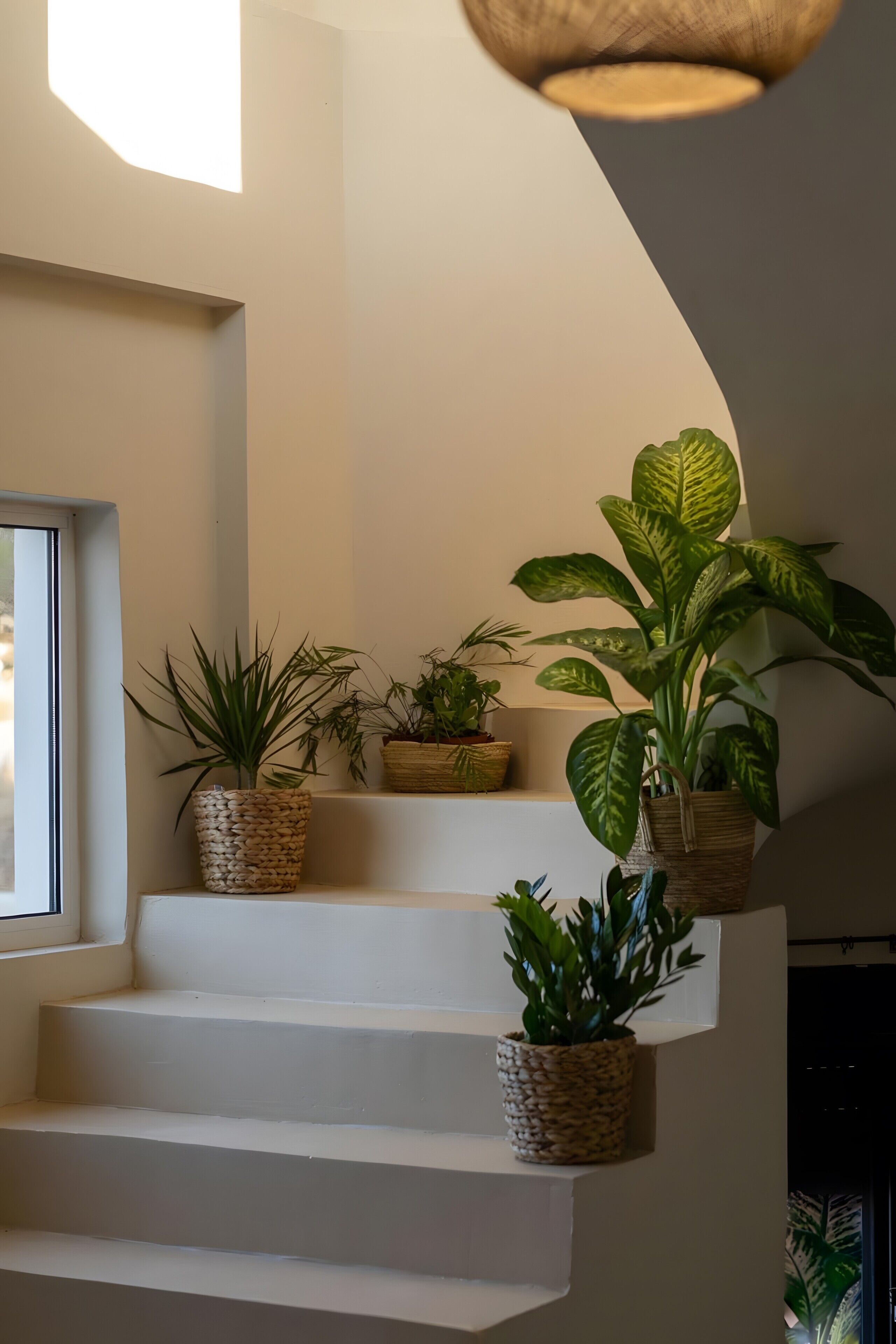 Uma escadaria com vários degraus, cada um decorado com uma cesta de vime contendo uma planta.