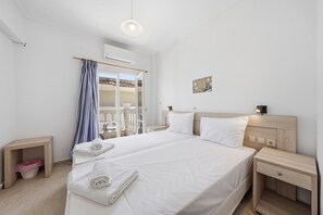 Een hotelkamer met een groot bed, nachtkastjes, een kledingkast en een airconditioning.