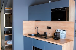 A compact kitchen with a sink, a coffee machine, and a built-in oven. - Vrbo Property (Tihany)