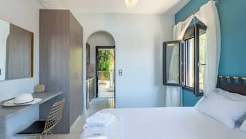 A modern hotel room with a bed, a desk, a chair, and a view of the outdoors.