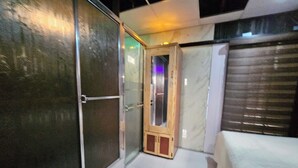 A hotel room with a sliding glass door, a wooden cabinet, and a bed with a white cover. - The Studio of Praise - by ZenBreak (Gasparillo)
