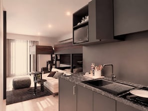 A modern kitchenette with a built-in stove, a sink, and a countertop.