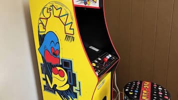 En Pac-Man arkadespilautomat ved siden af en skammel med Pac-Man-motiv.
