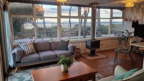 Ein gemütliches Wohnzimmer mit Sofa, Tisch, Fernseher und Kamin.