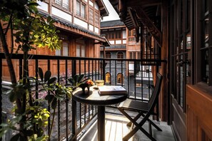 A balcony with a table, a chair, and a book. - Guanyin Shibaju Resort Hotel (Chongqing)