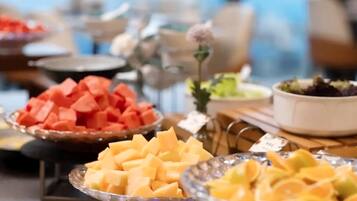 Buffet com diversas frutas e saladas.