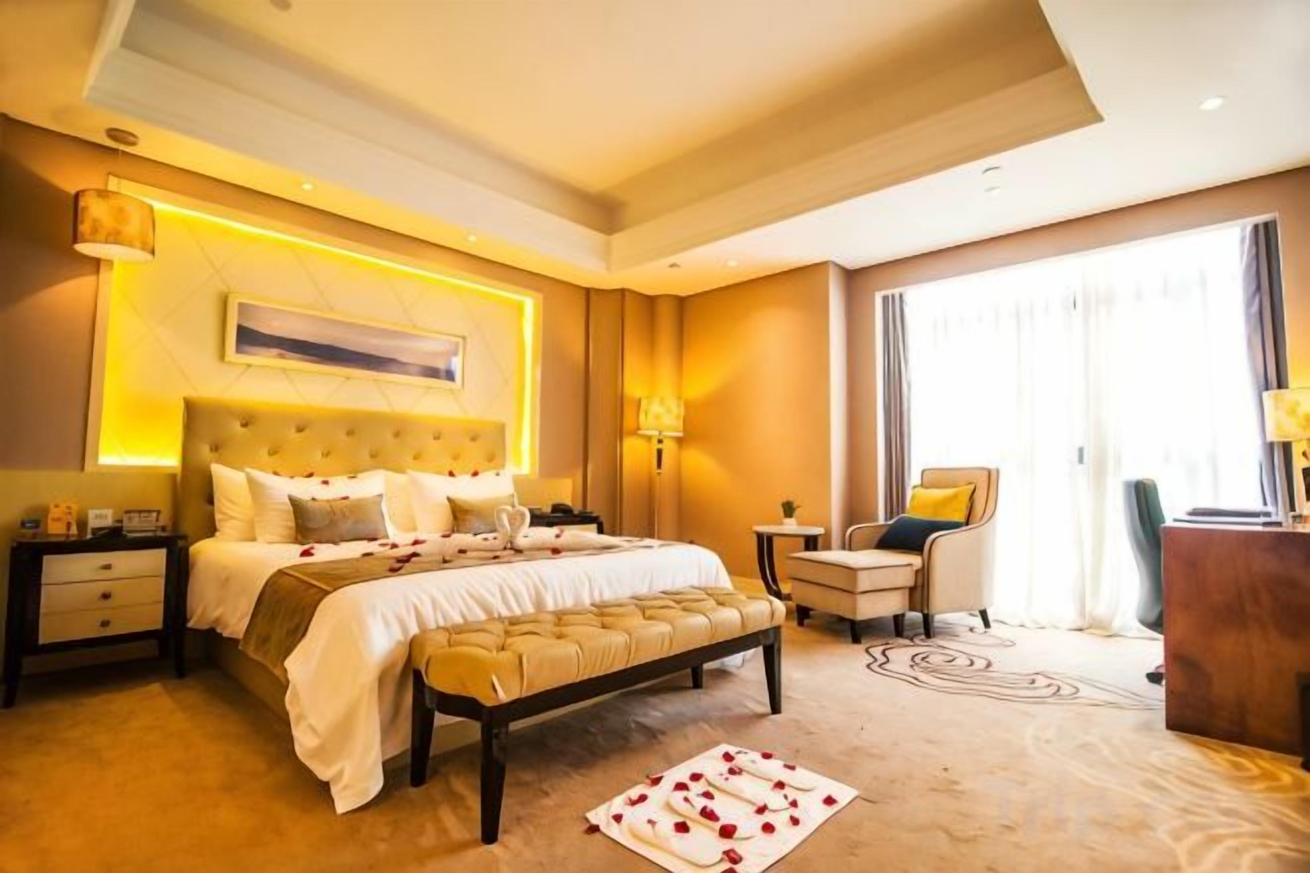 A hotel room with a large bed, bedside tables, a desk, and a chair.