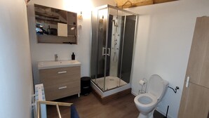 Ein Badezimmer mit Dusche, Toilette und Waschbecken.