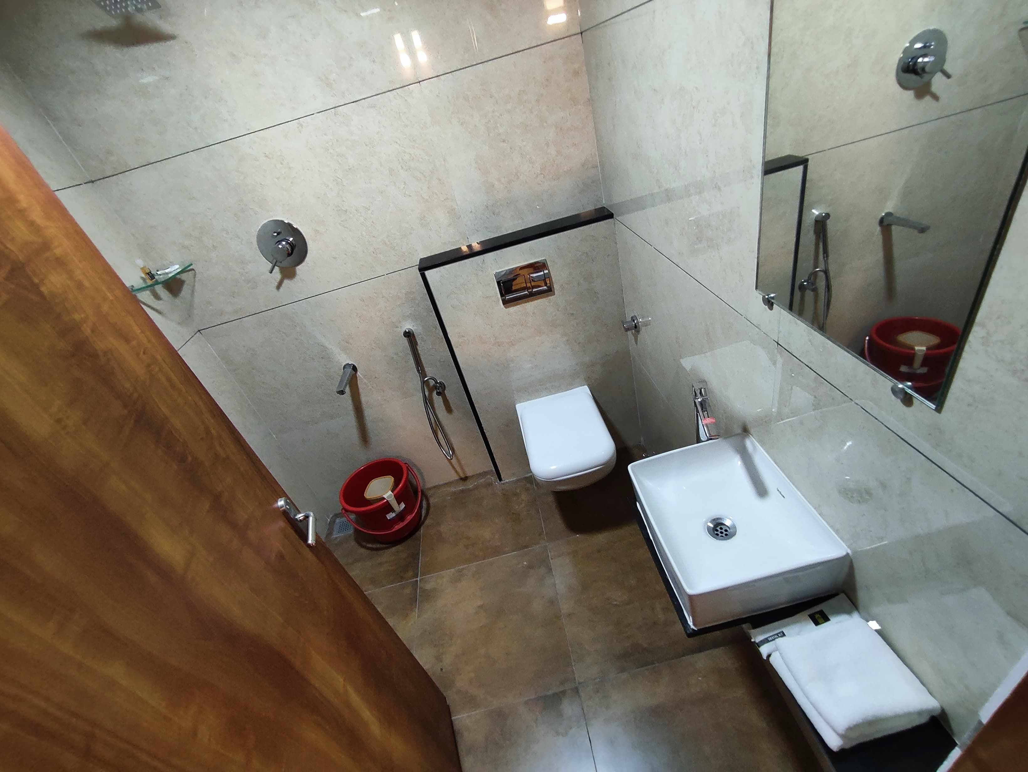 Casa de banho com sanita, lavatório e chuveiro.