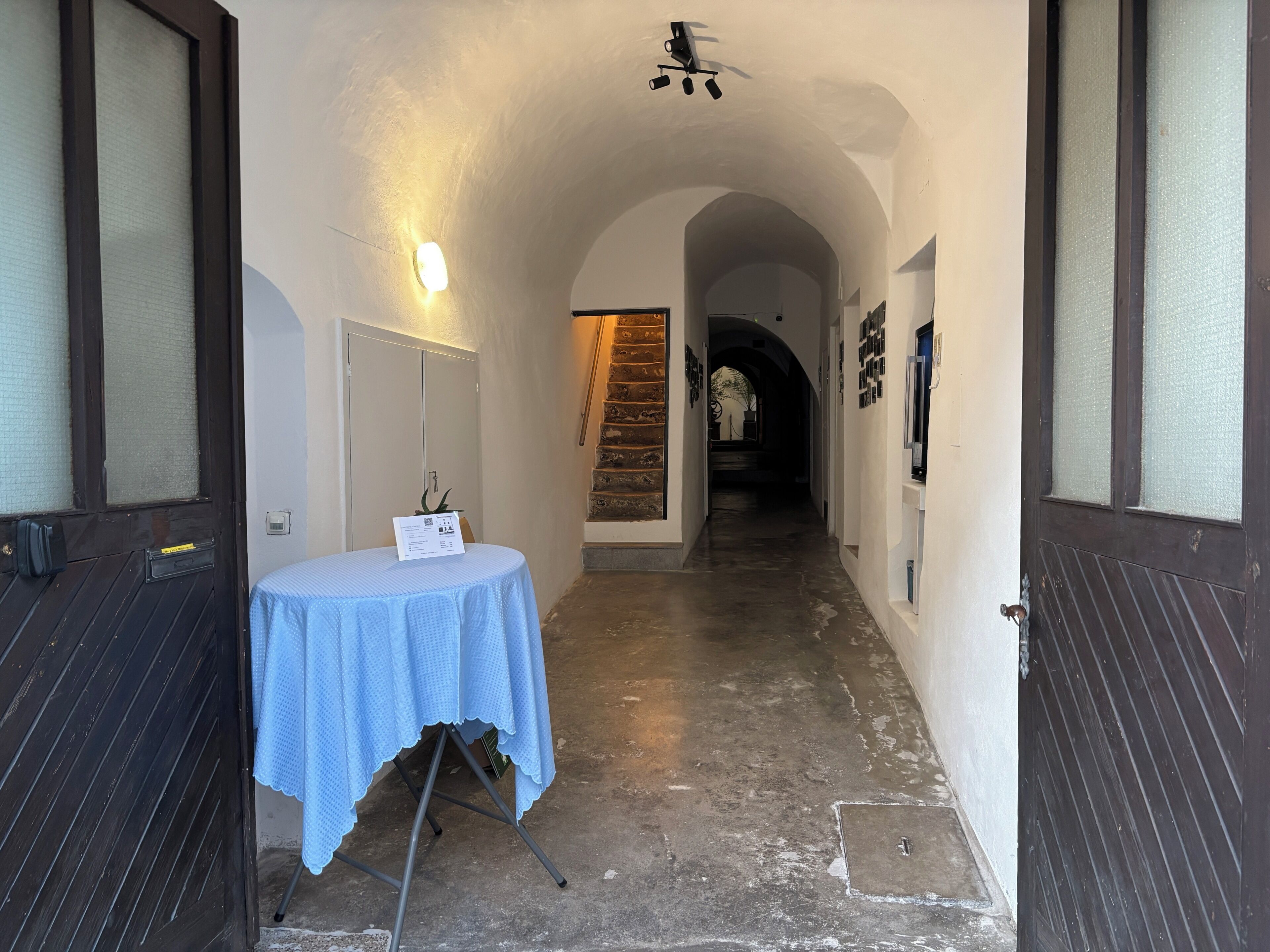 A hallway with a table, a staircase, and a door.