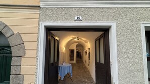 En gang med skilt med nummer 10, et bord med blåt stoflagne og en stenbuet indgang.