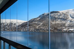 A view of a lake with snow-covered mountains and a town in the background. - Eight floor Premium Waterfront Penthouse (Tromsø)