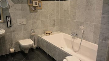 A modern bathroom with a toilet, sink, and bathtub.