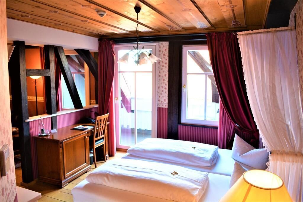 A room with a bed, a desk, and a chair.