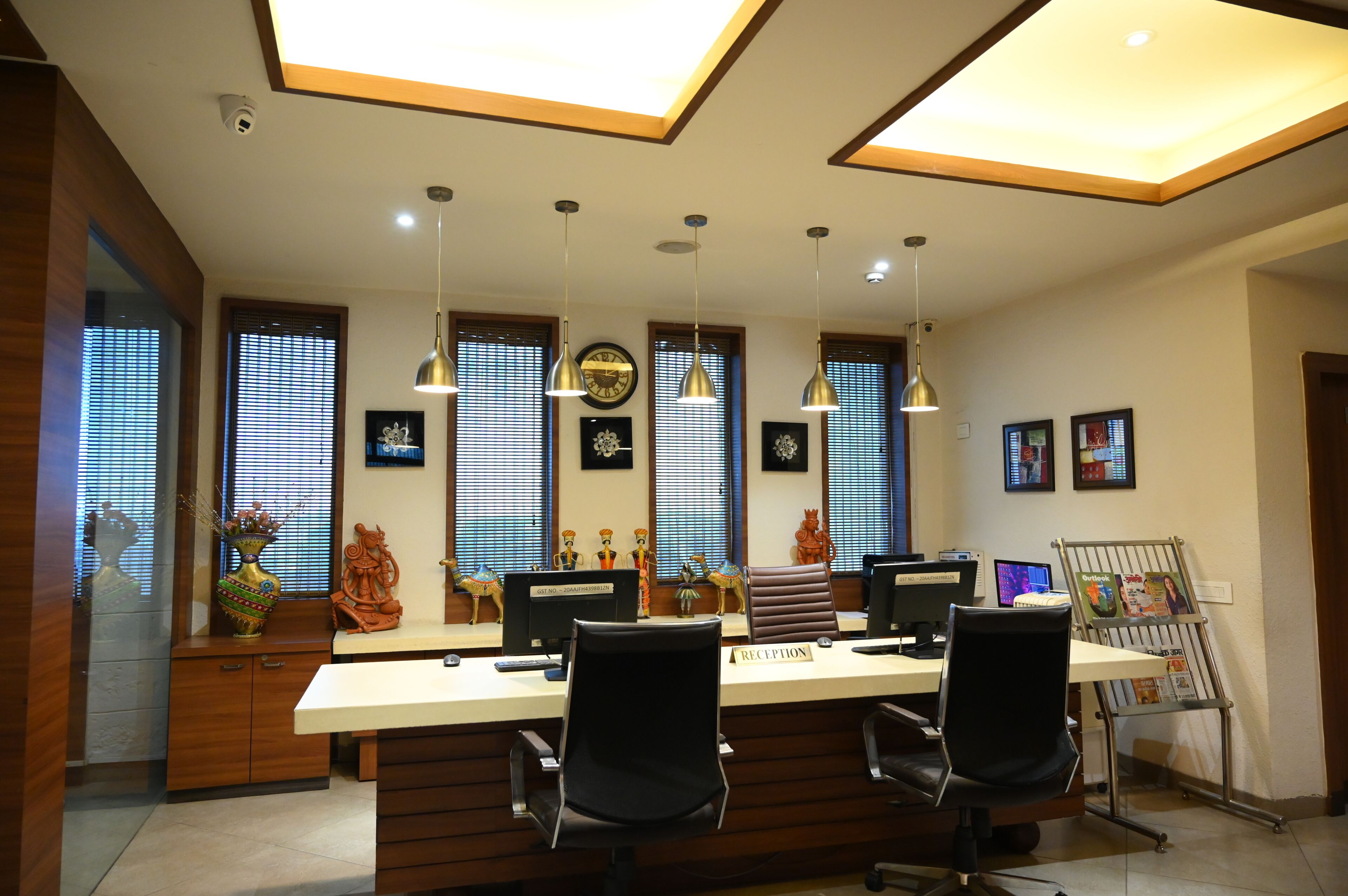 A reception area with a long counter, multiple chairs, and a computer setup.