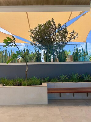 A covered outdoor area with planters, a bench, and a clear sky. - Stylish 1BR in Nyali with Pool, WiFi & Beach Access (Mombasa)
