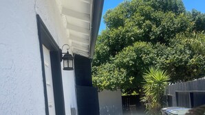 A residential area with a white house, an air conditioning unit, a tree, and a trash bin. - Spacious 4-bedroom building with AC in amazing Pittsburg (Pittsburg)