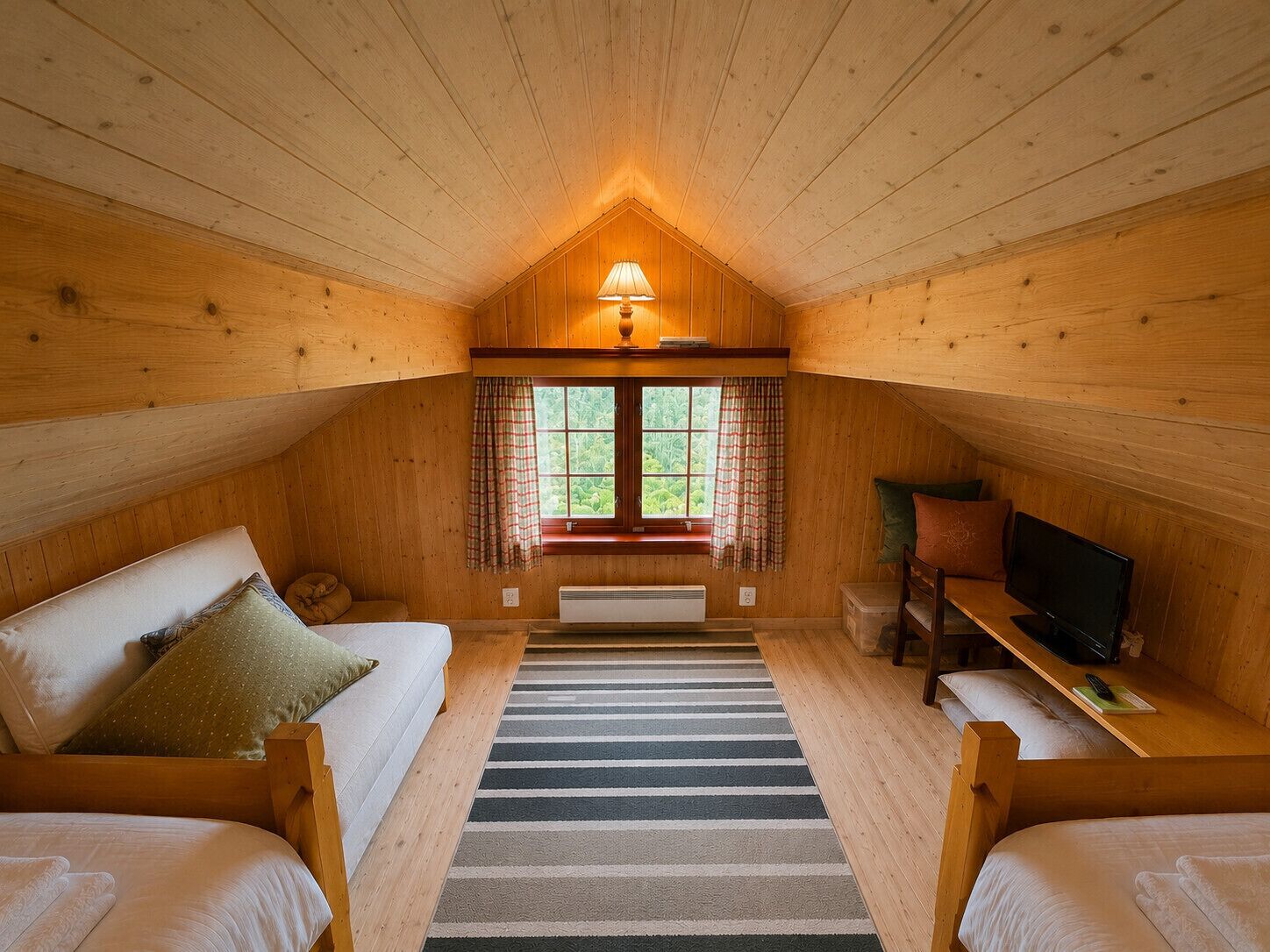 Et hyggeligt værelse med to senge, et fjernsyn, et vindue med gardiner og en lampe.