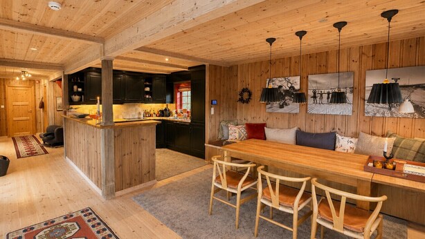 A wooden interior with a dining area, kitchen, and living space. - Spacious cabin with beautiful Geilo views (Hol)