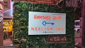 Placa indicativa do Neeladrin Inn com um painel de parede verde decorativo.