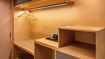 A compact, modern room with built-in shelving, a desk, and a hanging light fixture.