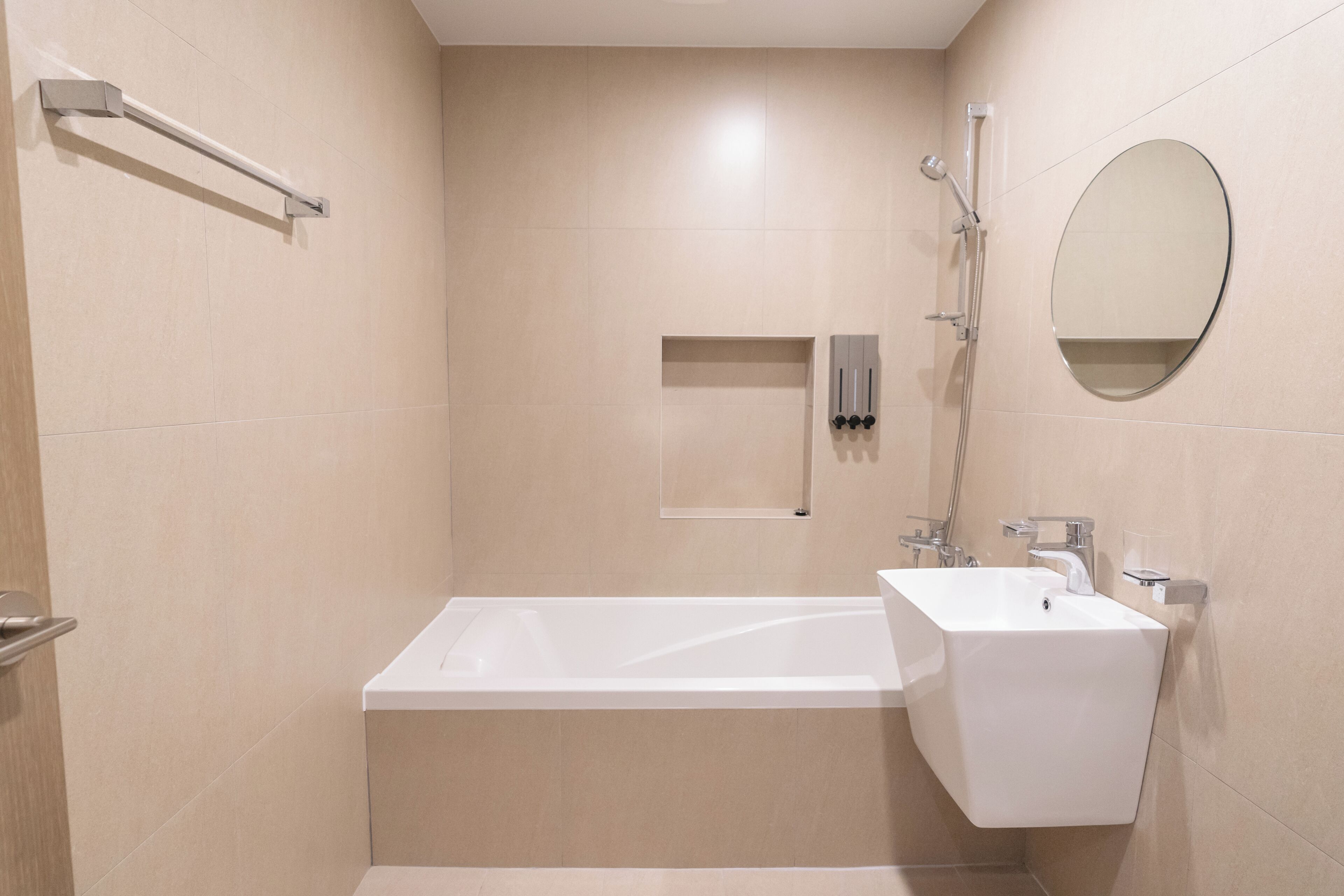 Un baño moderno con bañera, lavamanos, ducha y espejo.