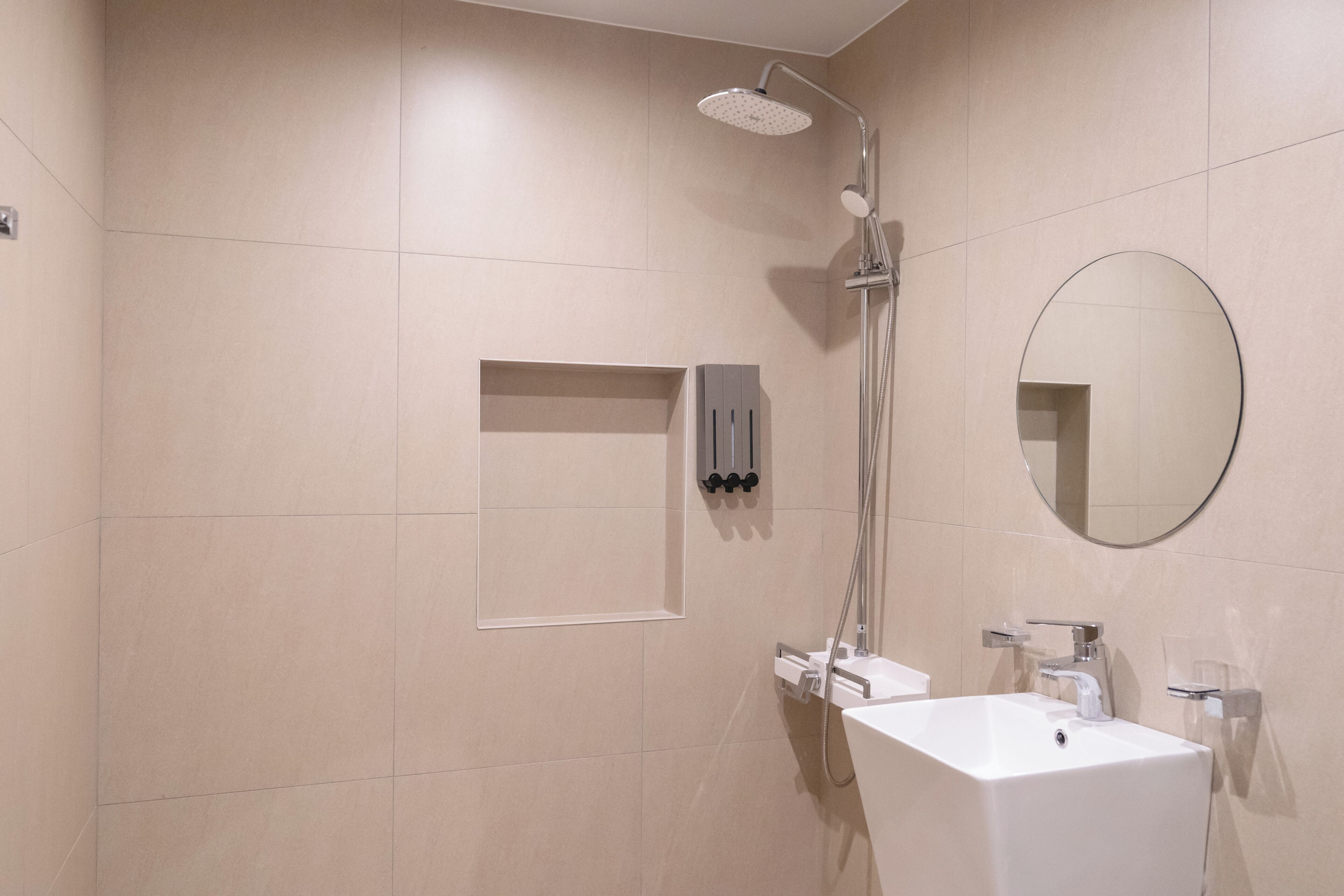 Ein modernes Badezimmer mit Dusche, Waschbecken und Spiegel.