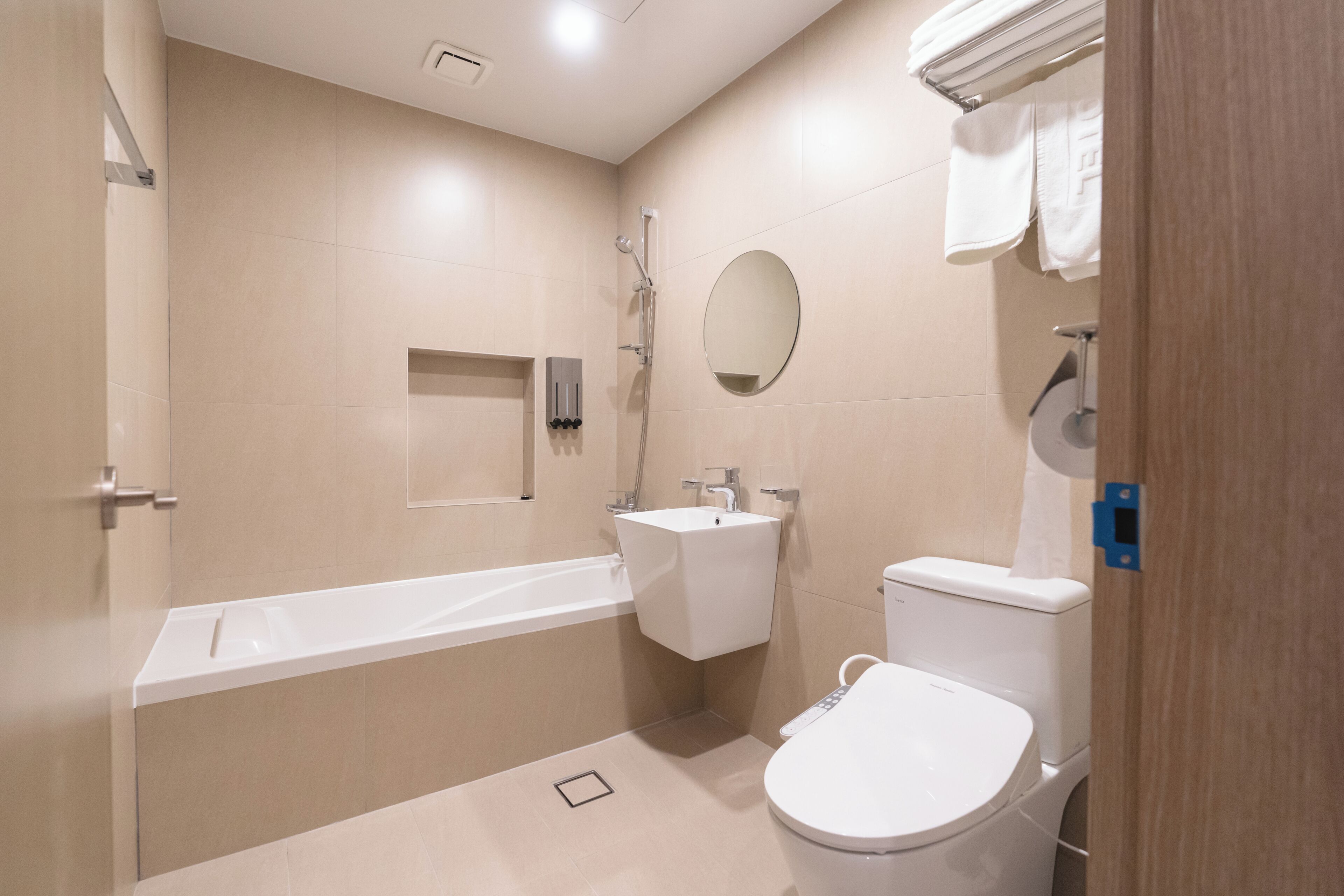 Un baño moderno con bañera, inodoro, lavabo y espejo.