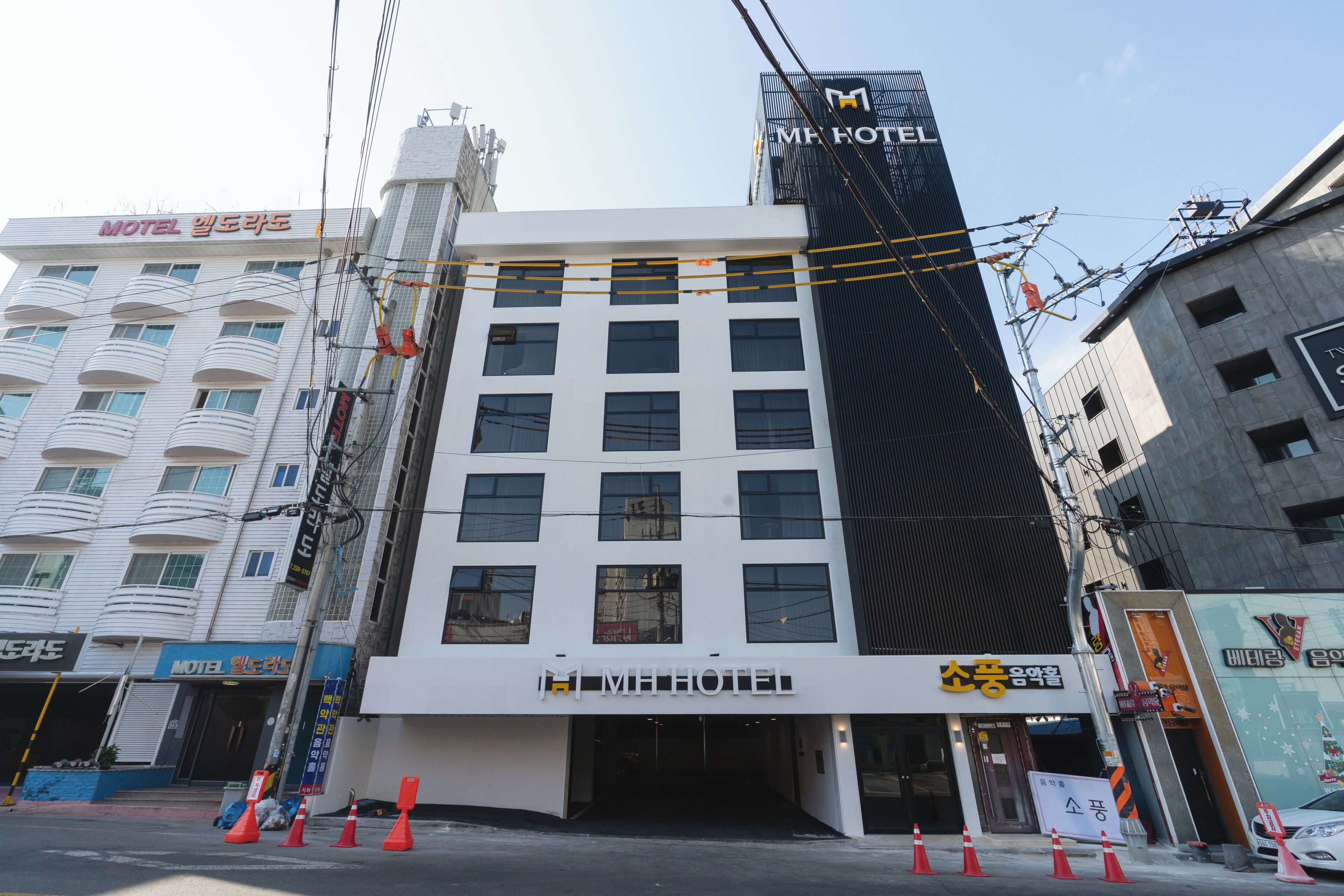 A hotel building with multiple floors, a modern facade, and a prominent sign for the hotel.