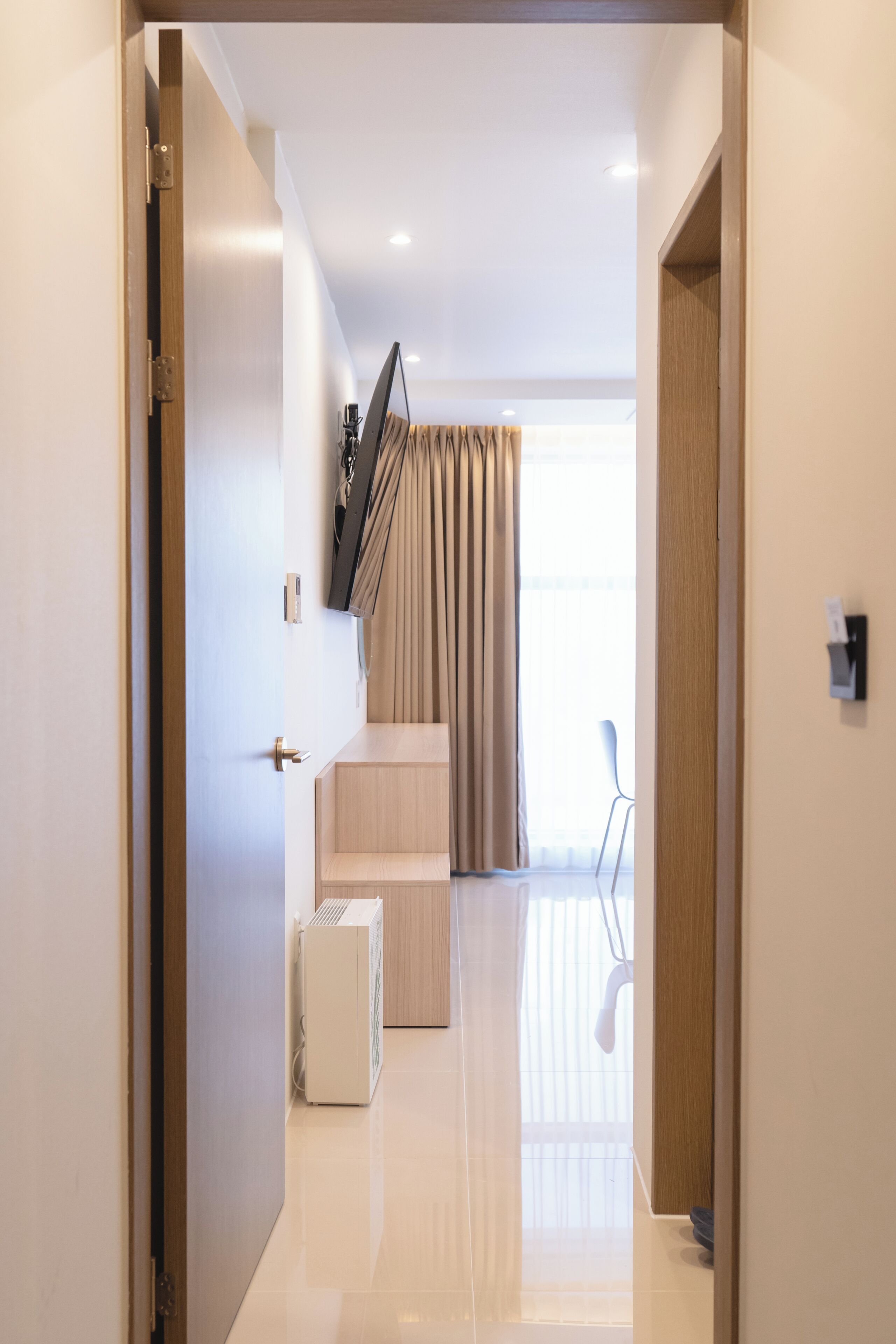Habitación de hotel moderna con escalera, televisor de pantalla plana, radiador y vistas al exterior.