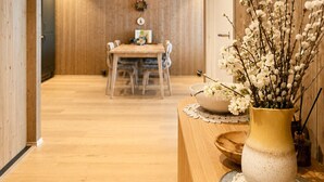 Un intérieur en bois comprenant un coin repas, un vase avec des fleurs et une carte accrochée au mur.