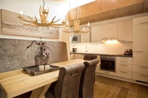 A modern kitchen with white cabinets, a microwave, and a built-in oven. - Scenic Alpine Stay with Balcony Views and Sauna (Neukirchen am Grossvenediger)