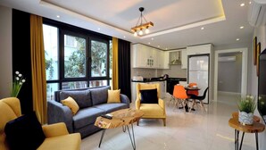 Una sala de estar moderna con un sofá, sillones, una mesa de centro y un comedor con sillas y una mesa.