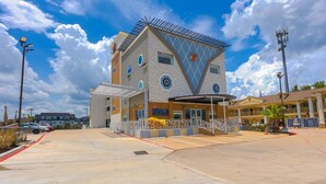 A hotel with a modern architectural design, featuring a prominent triangular facade, multiple windows, and a covered entrance area.