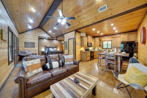 Ein Holzblockhaus-Interieur mit Wohnzimmer, Essbereich und Küche.
