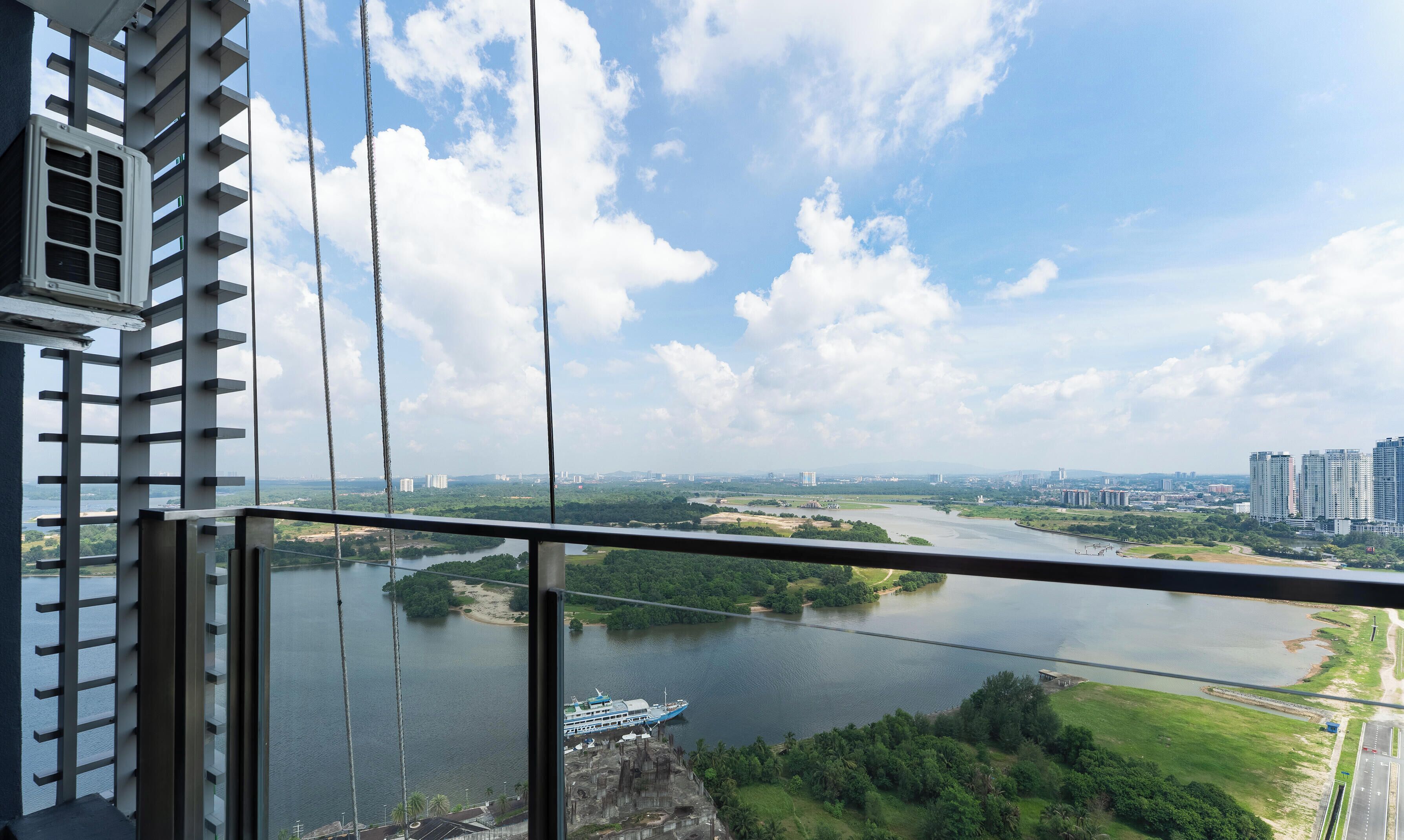 A high-rise building with a view of a river and a bridge.