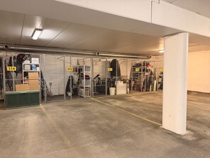 A parking garage with numbered parking spaces and metal security cages.