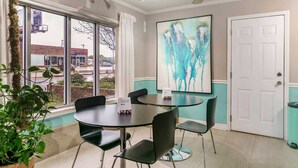 A conference room with a large window, a ceiling fan, and a painting on the wall. - Myrtle Beach SC | 3 full bed (Myrtle Beach SC)